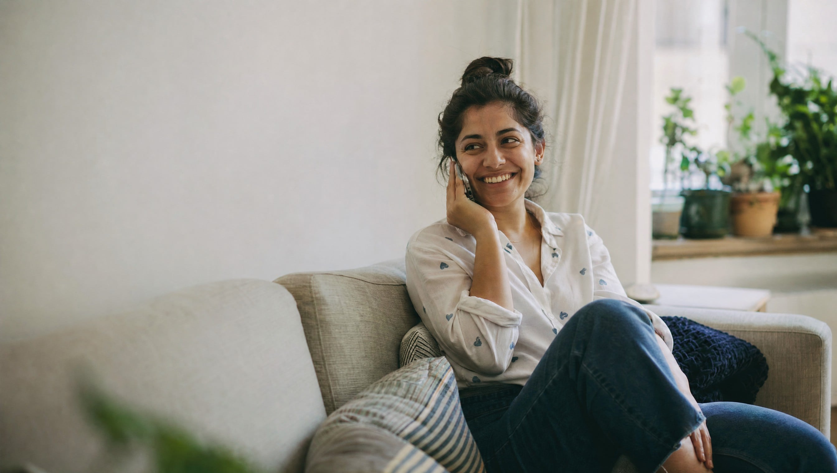 A person smiling on a phone call at home