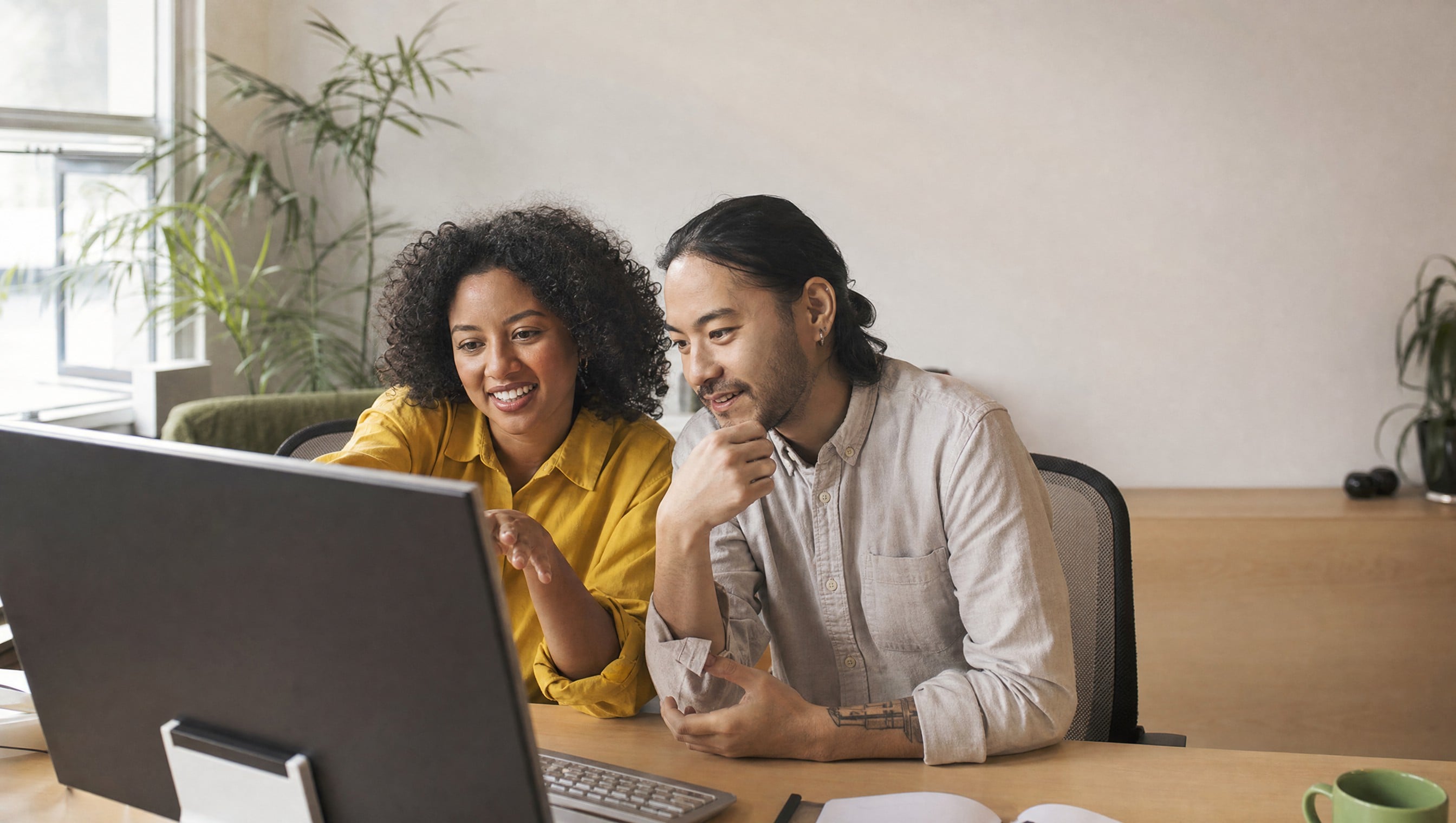Two colleagues looking at a screen together